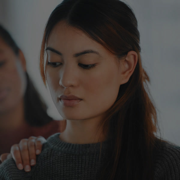 A supportive hand resting on someone’s shoulder during a difficult moment